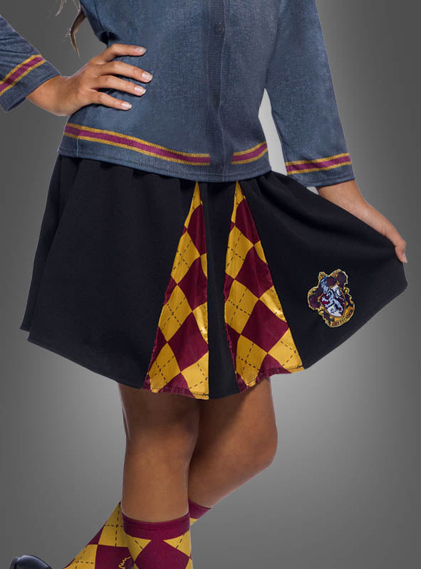 Ein Kind trägt das „Kinder Gryffindor Rock Harry Potter“-Outfit, bestehend aus einem schwarzen Rock mit roten und gelben Rautenmustern und einem von Gryffindor inspirierten Wappen, kombiniert mit passend gemusterten Socken und einem blauen Oberteil – ein bezaubernder Look, ideal für jedes Harry-Potter-Kostüm oder jede Kinderverkleidung.