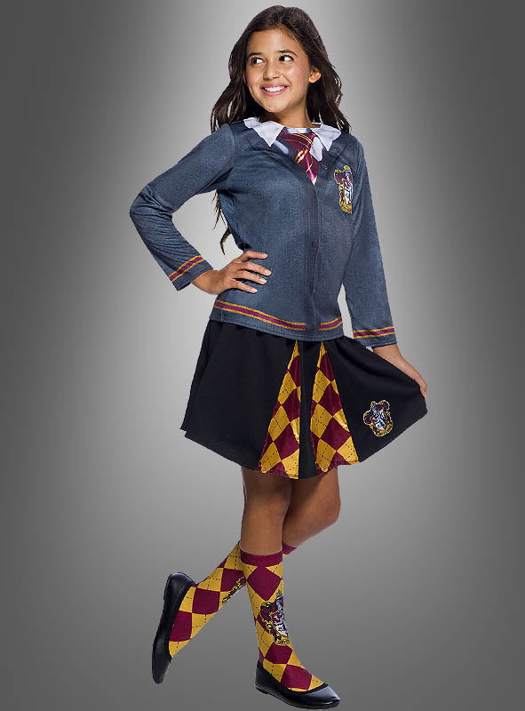 Ein Mädchen, das das „Kinder Gryffindor Rock Harry Potter“-Outfit trägt, kombiniert mit einer grauen Jacke und passenden Socken, steht vor einem grauen Hintergrund mit Farbverlauf.