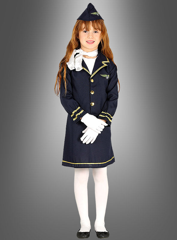 Ein Kind steht mit dem Gesicht nach vorne, gekleidet im Stewardess-Kinderkostüm – eine marineblaue Pilotenuniform mit goldenen Verzierungen, weißen Handschuhen, weißen Strumpfhosen, schwarzen Schuhen und einer passenden Mütze –, perfekt für den Karneval oder als Stewardess-Kostüm für Mädchen – vor einem grauen Hintergrund mit Farbverlauf.