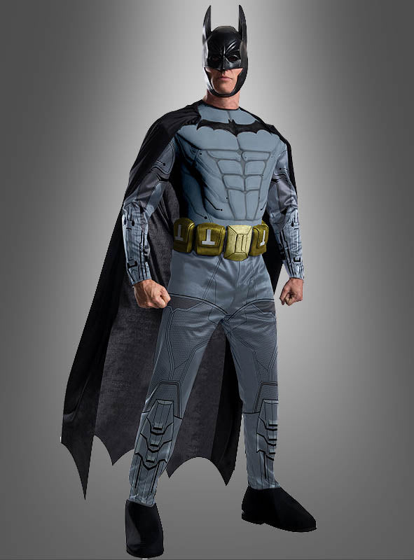 Eine Person im „Batman: Arkham City“-Kostüm mit Umhang, Kapuze, gepolsterter Brustplatte, Werkzeuggürtel und Stiefeln steht vor einem schlichten grauen Hintergrund – perfekt für Superheldenpartys oder Fans der „Arkham“-Videospielreihe.