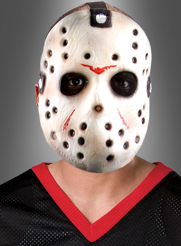 Eine Person trägt die Jason-Voorhees-Maske aus „Freitag, der 13.“ mit schwarzen und roten Markierungen, dazu ein schwarzes Netzshirt mit rotem Rand, vor einem grauen Hintergrund mit Farbverlauf – ein auffälliger Look, perfekt für Horrorfilmfans und Liebhaber von „Freitag, der 13.“.