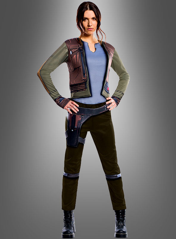 Eine Frau steht mit den Händen in den Hüften da. Sie trägt ein von Science-Fiction inspiriertes Outfit, das dem „Star Wars: Rogue One“-Kostüm von Jyn Erso für Erwachsene nachempfunden ist und aus einer eleganten Jacke, einem Funktionsgürtel und schwarzen Stiefeln besteht – wodurch der authentische Look dieses offiziellen „Star Wars“-Kostüms perfekt zur Geltung kommt –, vor einem schlichten Hintergrund mit Farbverlauf.