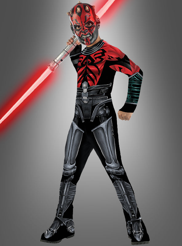 Ein Kind im Darth-Maul-Cyborg-Kostüm aus der Serie „The Clone Wars“, das ein rotes Doppelklingen-Lichtschwert in der Hand hält und vor einem schlichten grauen Hintergrund steht.
