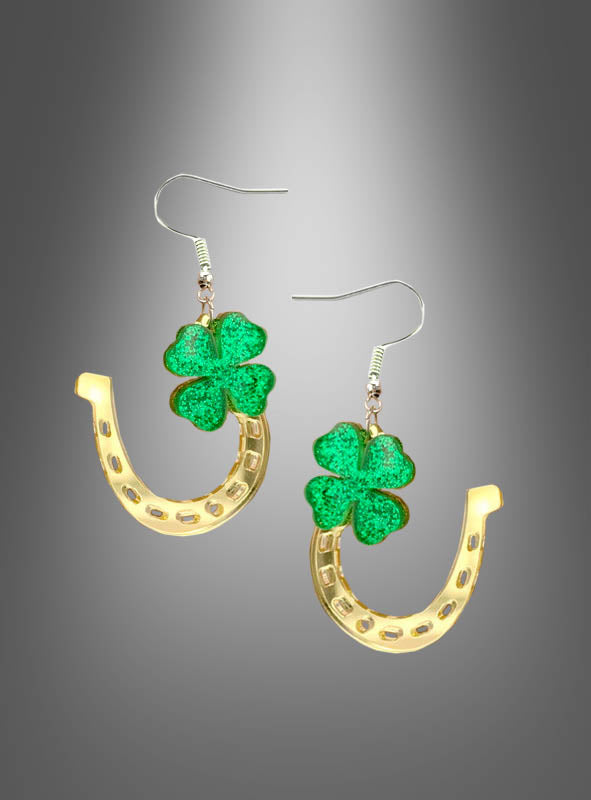 „St. Patrick’s Day Ohrringe Kleeblatt“ – ein Paar goldene Hufeisen-Ohrringe, verziert mit grünen, glitzernden vierblättrigen Kleeblättern, präsentiert vor einem grauen Hintergrund mit Farbverlauf.