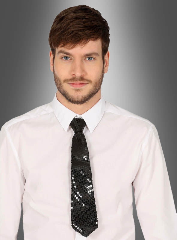 Ein Mann mit kurzen braunen Haaren und Bart trägt ein weißes Hemd und eine schwarze Pailletten-Krawatte (Unisex) und steht vor einem grauen Hintergrund mit Farbverlauf. Dieses stilvolle Accessoire ist das perfekte Karnevalsaccessoire, um seinen Look abzurunden.