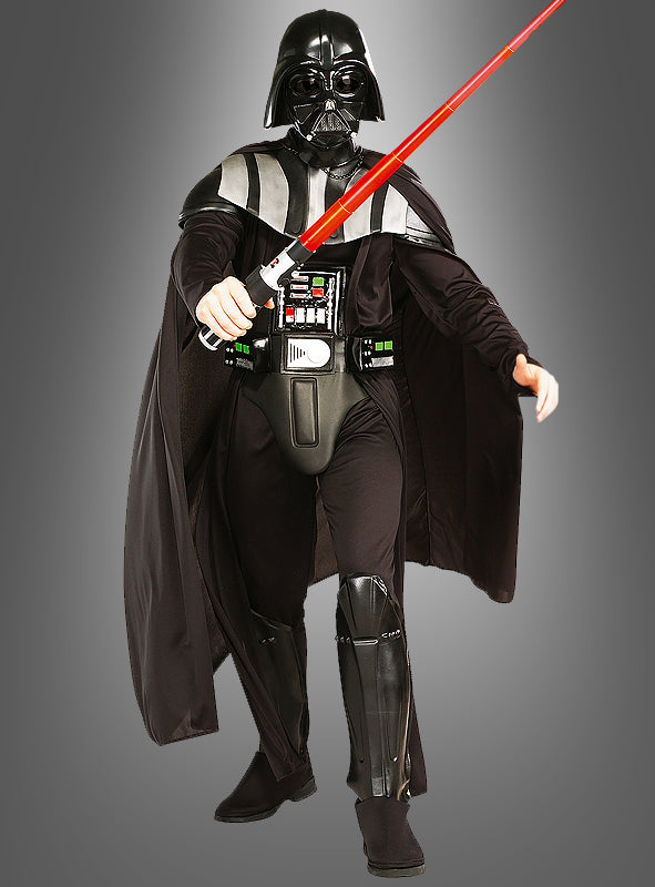 Eine Person, die das „Darth Vader Kostüm für Erwachsene – Star Wars Deluxe“ trägt – komplett mit schwarzer Rüstung, Umhang, Maske und einem roten Lichtschwert –, steht vor einem schlichten grauen Hintergrund – ein ideales Kostüm für Erwachsene.