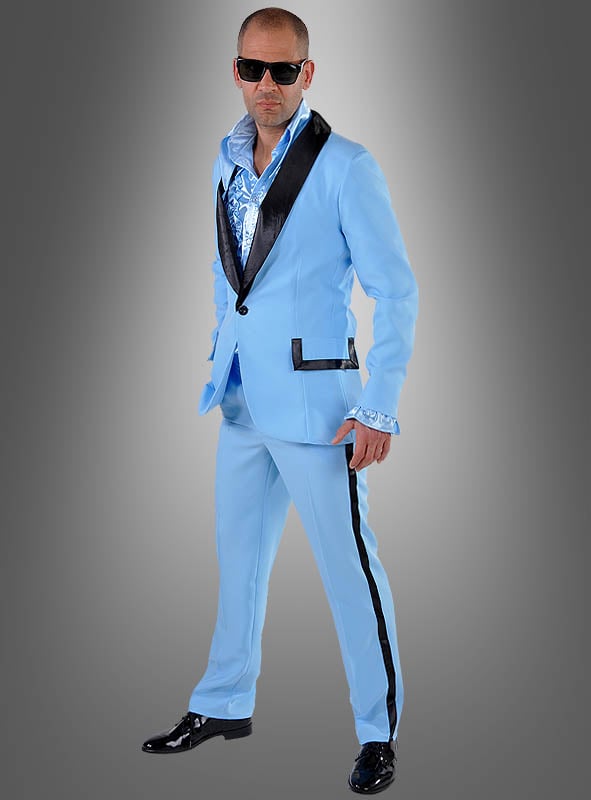 Ein Mann im „Blauer Anzug 50er Jahre für Herren“ mit schwarzen Akzenten, einem glänzenden Hemd und einer Sonnenbrille steht vor einem grauen Hintergrund mit Farbverlauf und verkörpert mühelos den Rockabilly-Look und das zeitlose Flair von Vintage-Herrenbekleidung.