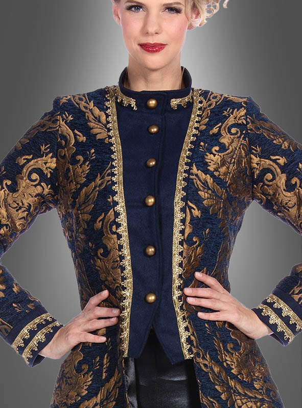 Eine Frau, die die „Luxus Barock Brokat Jacke Damen“ trägt – eine dunkelblaue, mit Goldstickereien verzierte Brokatjacke mit Messingknöpfen, die von Mänteln im Barockstil inspiriert ist –, steht mit den Händen in den Hüften vor einem grauen Hintergrund.
