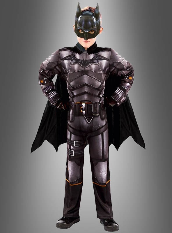 Ein Kind steht mit den Händen in den Hüften und trägt das Batman Original Kinderkostüm – komplett mit Umhang und Maske – und blickt selbstbewusst vor sich hin vor einem grauen Hintergrund. Dieses auffällige DC Comics-Lizenzkostüm fängt den ikonischen Superhelden-Look für jeden jungen Fan perfekt ein.