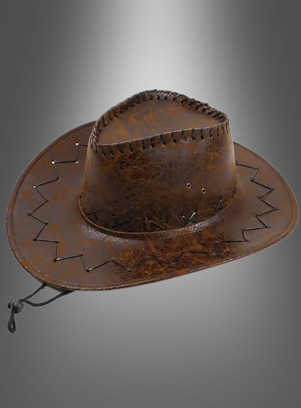 Wir präsentieren den „Cowboy Hut“ für Damen und Herren (Unisex): ein brauner Cowboyhut aus Leder mit Ziernähten und einem verstellbaren Kinnriemen – perfekt, um jedes Cowboykostüm abzurunden. Dargestellt vor einem grau verlaufenden Hintergrund.