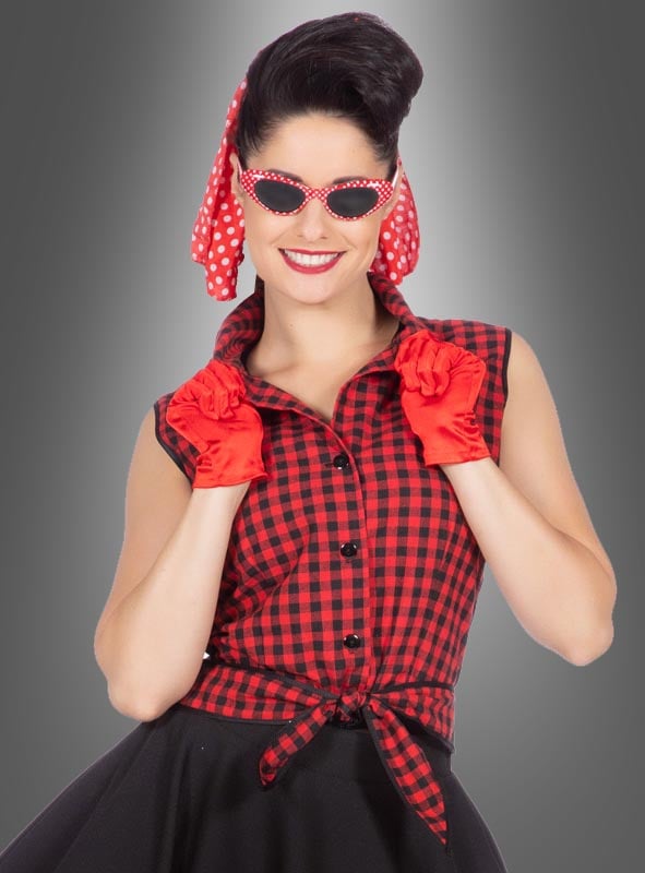 Eine Frau trägt das Rockabilly-Kleid „Rizzo“ im Stil der 50er Jahre, ein rot-schwarz kariertes, ärmelloses Kleid, dazu ein rotes Kopftuch mit Polka-Dots, rote Handschuhe und eine dazu passende rote Sonnenbrille mit Polka-Dots. Sie lächelt vor einem grauen Hintergrund.