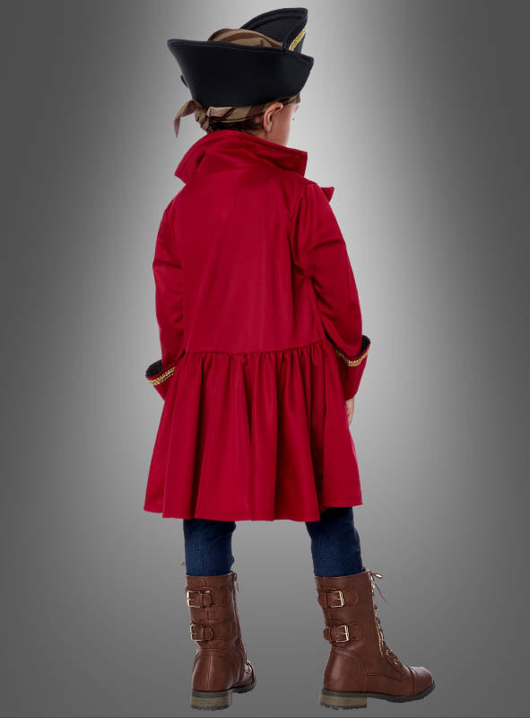 Ein Kind, gekleidet in einen roten Mantel, eine dunkle Hose, braune Stiefel und einen schwarzen Piratenhut, steht mit dem Rücken zum Betrachter vor einem grauen Hintergrund und verkörpert damit perfekt den Abenteuergeist des Piratenkostüms „Shorty“ für Kinder.