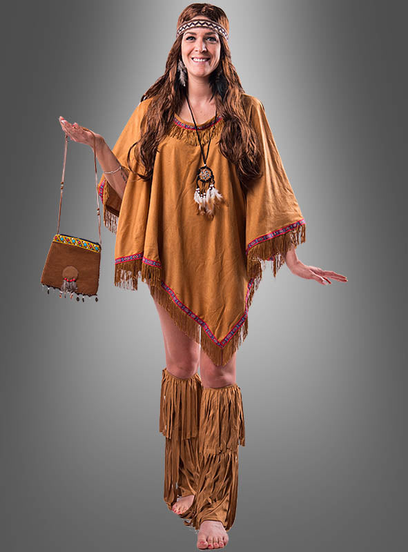 Vor einem grauen Hintergrund mit Farbverlauf steht eine Frau barfuß und trägt das braune „Wandelbarer Poncho mit Fransen“-Hippie-Indianer-Kostüm mit Fransen, ergänzt durch ein Stirnband und eine dazu passende Tasche.
