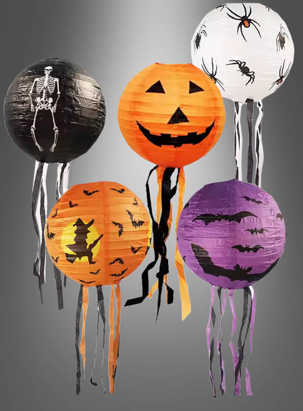 Das 5-teilige „Halloween-Papierlaternen-Deko“-Set umfasst Laternen mit Motiven wie Skelett, Kürbislaterne, Hexe, Fledermaus und Spinne, die jeweils mit hängenden Bändern verziert sind und vor einem grauen Hintergrund ein festliches Halloween-Ambiente schaffen.