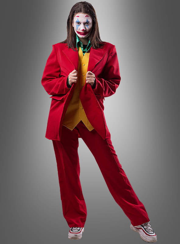 Eine Person trägt den „Roten Anzug im Joker-Stil“ zusammen mit einer gelben Weste, einem grünen Hemd und Clown-Make-up vor einem grauen Farbverlauf – das perfekte Herrenkostüm im klassischen Joker-Stil.