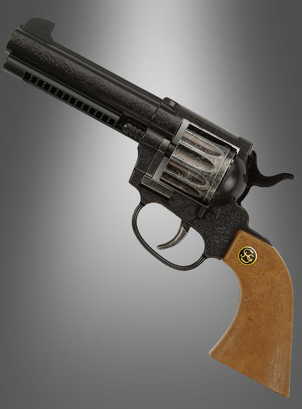 Eine „Peacemaker“-Revolver-Spielzeugpistole in Schwarz und Silber mit gravierten Details und einem Holzgriff wird vor einem grauen Hintergrund mit Farbverlauf präsentiert – ideal als Pistole für das Wilde-Westen- oder Cowboy-Kostüm.