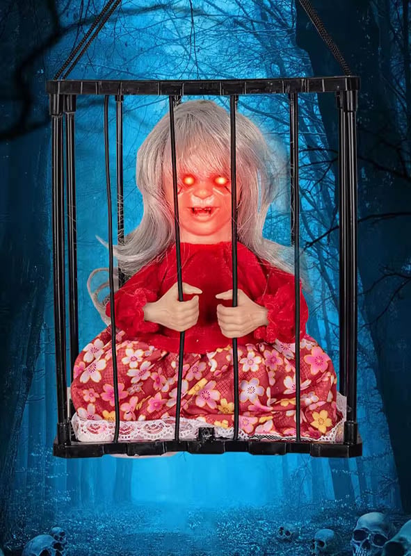 Eine animierte Halloween-Figur im Käfig mit leuchtend roten Augen und langen grauen Haaren sitzt in einem schwarzen Käfig, umgeben von einem dunklen, nebligen Wald mit blauem Schimmer – eine unheimliche Szene, perfekt als Grusel-Dekoration oder für alle, die nach animierten Horrorpuppen als Halloween-Figuren im Käfig suchen.