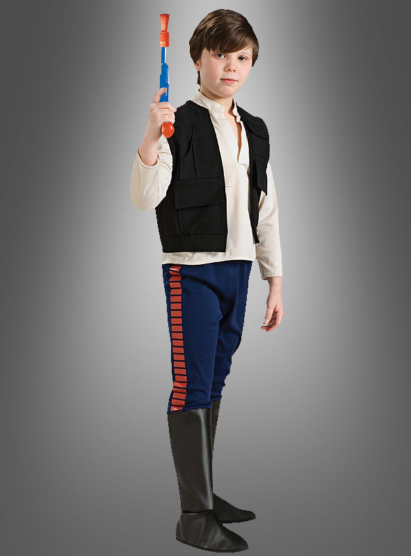 Ein Kind, das das Han-Solo-Star-Wars-Kinderkostüm trägt – bestehend aus einem weißen Hemd, einer schwarzen Weste, einer blauen Hose mit roten Streifen und schwarzen Stiefeln –, steht selbstbewusst mit einem Spielzeugblaster in der Hand vor einem schlichten grauen Hintergrund. Dieses Kostüm eignet sich ideal für jeden Kindergeburtstag oder jede Themenparty.