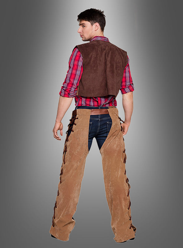 Ein Mann im Cowboy-Kostüm für Herren – ein rotes Karohemd, eine braune Cowboyweste, Jeans und hellbraune Lederchaps – steht mit dem Rücken zur Kamera vor einem grauen Hintergrund mit Farbverlauf und verkörpert damit den rauen Charme des klassischen Western-Looks.