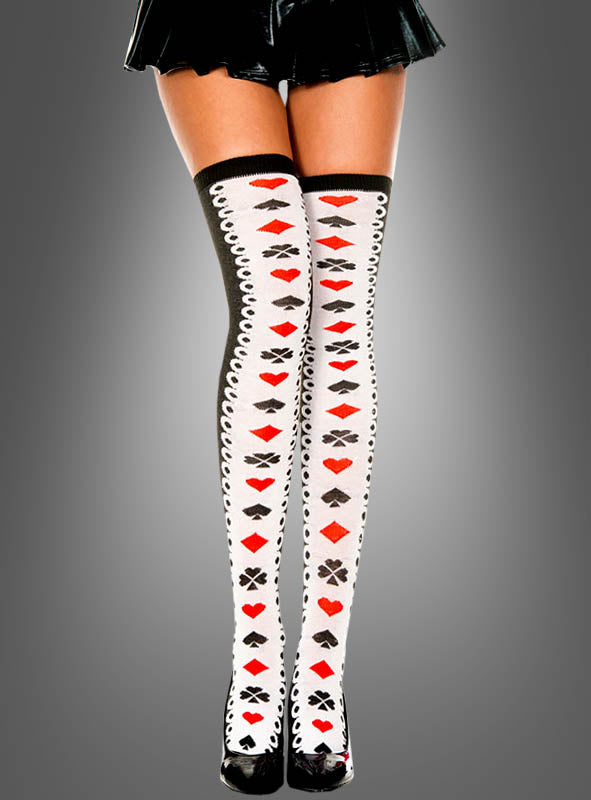 Eine Person trägt kniehohe, halterlose „Kartenspiel“-Strümpfe mit Spielkartensymbolen und schwarzen High Heels, die vor einem grauen Hintergrund vom mittleren Oberschenkel abwärts zu sehen sind – ein perfektes „Alice im Wunderland“-Accessoire für jedes Herzkönigin-Kostüm.