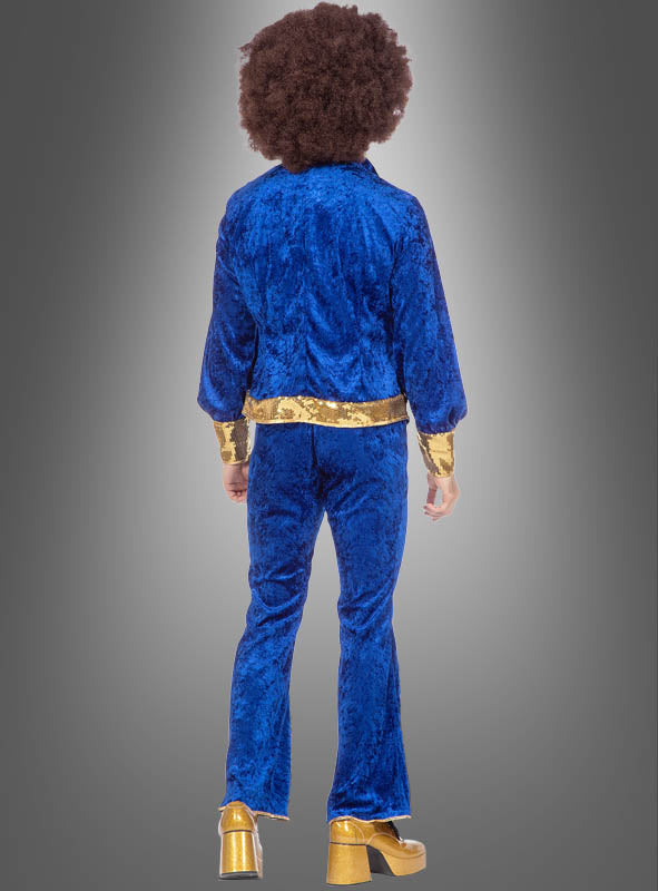 Eine Person mit einer voluminösen Afrofrisur, die den „Glitzer Disco Anzug blau-gold“ trägt – aus funkelndem blauem Stoff mit goldenen Manschetten und passenden goldenen Plateauschuhen –, steht mit dem Rücken zur Kamera vor einem grauen Hintergrund mit Farbverlauf – eine perfekte Hommage an den unverwechselbaren Stil eines 70er-Jahre-Kostüms.