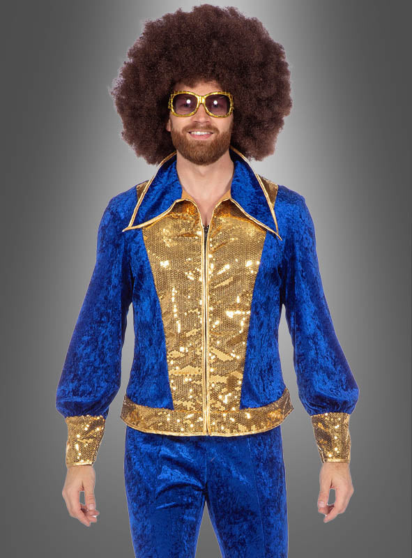 Ein Mann, der den „Glitzer Disco Anzug blau-gold“ trägt – einen schillernden Disco-Anzug aus blauem Samt und goldenen Pailletten mit ausgestellten Ärmeln –, dazu eine goldene Sonnenbrille und eine große braune Afro-Perücke. Dieses auffällige 70er-Jahre-Kostüm hebt sich deutlich von einem grauen Hintergrund mit Farbverlauf ab.