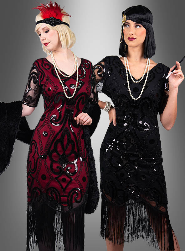 Zwei Frauen in „Halbarm 20er Jahre Retro Kleid Francis“-Kleidern – eine in Rot und eine in Schwarz –, kombiniert mit perlenbesetzten Haarbändern, Perlenketten und schwarzen Accessoires, posieren elegant vor einem grauen Hintergrund.