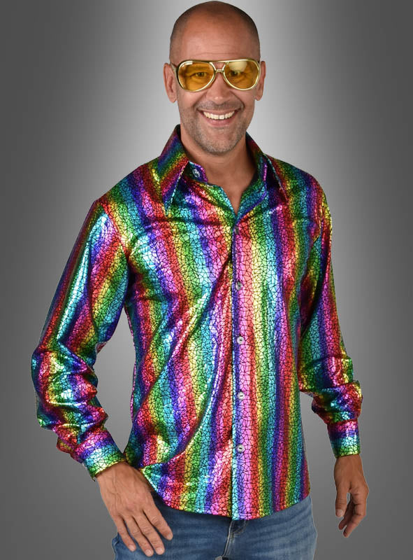 Ein lächelnder Mann mit gelber Sonnenbrille und einem glänzenden „Hologramm Party Hemd Regenbogen“, der vor einem grauen Hintergrund mit Farbverlauf steht.