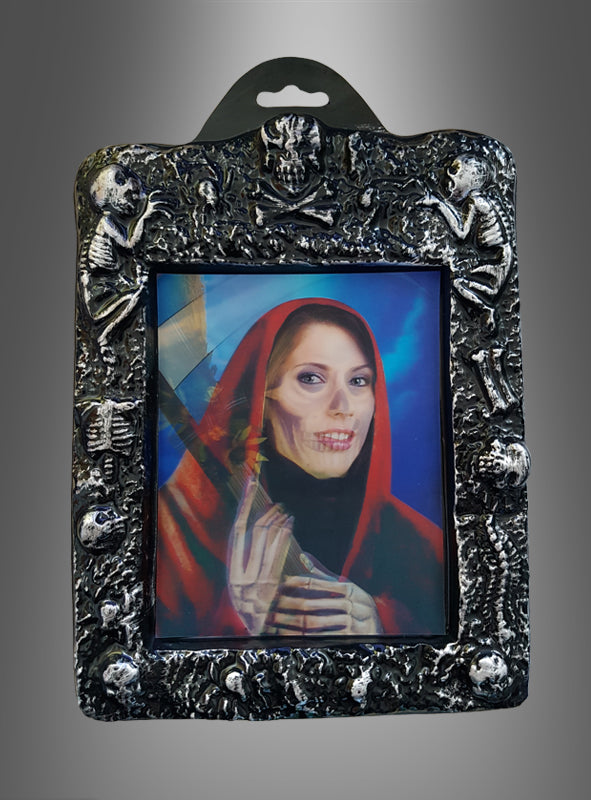 Das „Wackelbild Halloween Hologramm Bilder“ zeigt das faszinierende Porträt einer Frau mit roter Kapuze, das sich in eine Skelettfigur verwandelt – eingebettet in einen metallischen Rahmen, der mit Skeletten und Totenköpfen verziert ist. Die gruselige Szene wird durch holografische Tiefe und bemerkenswerte Detailtreue eingefangen.