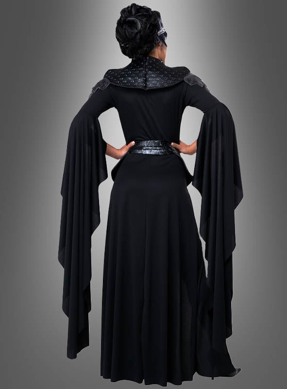 Eine Person, die das Kostüm der „Schwarzen Königin der Toten“ trägt – bestehend aus einem langen schwarzen Kleid mit dramatisch fließenden Ärmeln –, steht mit dem Rücken zu einem grauen Hintergrund mit Farbverlauf und strahlt dabei eine geheimnisvolle Eleganz aus.