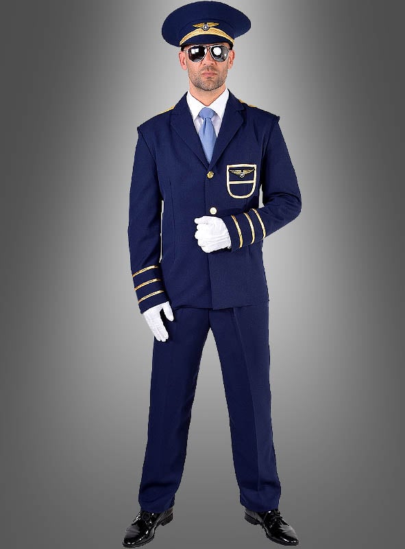 Ein Mann, der ein blaues „Pilot“-Kostüm für Herren mit goldenen Verzierungen, weiße Handschuhe, eine Sonnenbrille und einen passenden Hut trägt, steht vor einem grauen Hintergrund mit Farbverlauf.