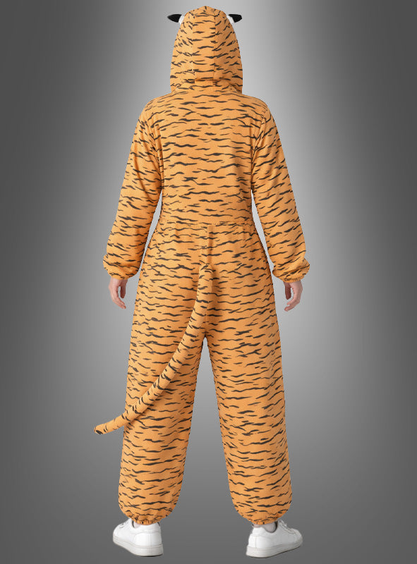 Eine Person, die ein Deluxe-Tigerkostüm aus Plüsch trägt – mit orange-schwarzen Streifen, Kapuze, Schwanz und Ohren –, steht mit dem Rücken zur Kamera vor einem grauen Hintergrund mit Farbverlauf.