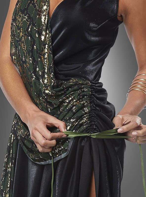 Eine Person, die das Medusa-Schlangenkostüm für Damen trägt – mit einem glänzenden schwarz-grünen Muster –, bindet sich ein grünes Band um die Taille, sodass nur ihr Oberkörper und ihre Hände zu sehen sind.