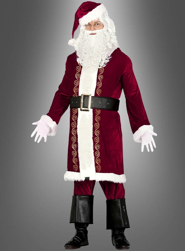 Eine Person in einem 5-teiligen Nikolauskostüm, bestehend aus einem klassischen roten Mantel, einem weißen Bart, einer Brille, einem schwarzen Gürtel, schwarzen Stiefeln mit markanten Stiefelüberzügen und weißen Handschuhen, die vor einem grauen Hintergrund steht.