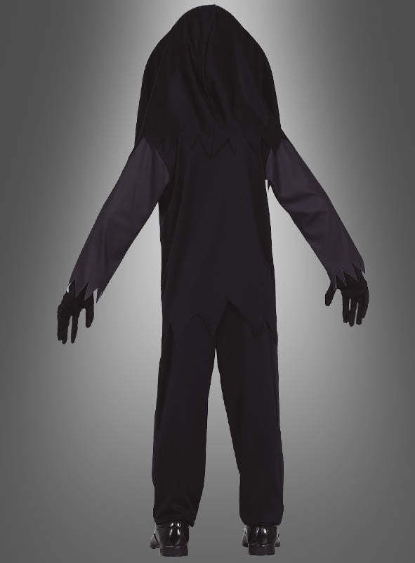 Eine Person steht mit dem Rücken zur Kamera und trägt das „Skelett-Kostüm mit Totenkopf für Kinder“ – ein schwarzes Kostüm mit Kapuze, dessen Ärmel und Saum gezackt sind – sowie schwarze Handschuhe und Schuhe vor einem grauen Hintergrund mit Farbverlauf.