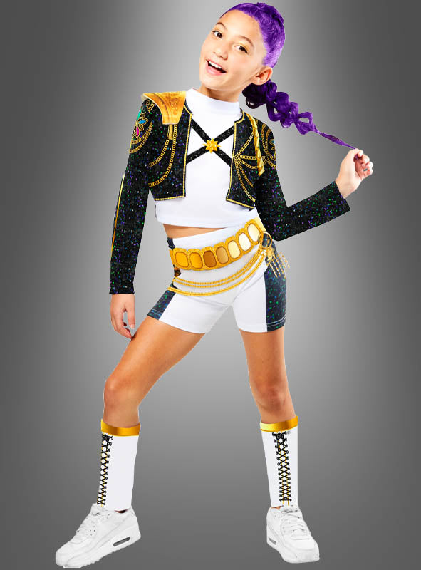 Ein junges Mädchen steht selbstbewusst vor einem grauen Hintergrund und trägt das K-Pop-Kostüm „Rumi Golden“ für Kinder: ein schwarz-gold-weißes Outfit bestehend aus Shorts, einer kurzen Jacke, kniehohen Socken und weißen Sneakers. Ihr lila Haar rundet das stilvolle Ensemble ab.