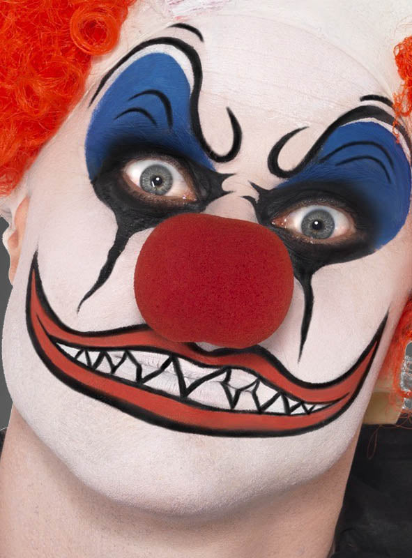 Nahaufnahme einer Person mit weißer Gesichtsbemalung aus der Schminke-Farbpalette „Fasching für Kinder und Erwachsene“, mit auffälligem blau-schwarzem Make-up, einer roten Clownsnase, einer orangefarbenen Perücke und einem groß gemalten Mund mit scharfen Zähnen – die perfekte Inspiration für Fasching- oder Kinderschmink-Motive.