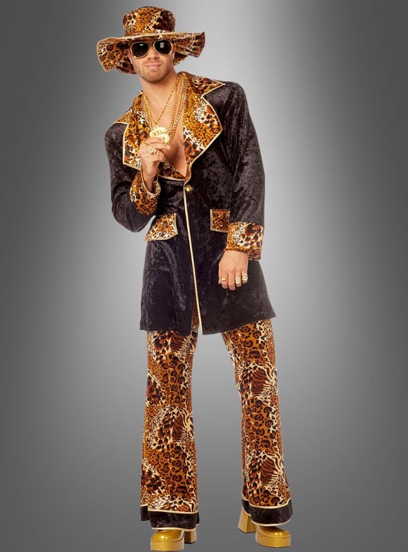 Eine Person, die das „Cooles Pimp Outfit Leopardenmuster“ trägt – komplett mit breitkrempigem Hut, Goldschmuck, Sonnenbrille und Plateauschuhen –, posiert vor einem grauen Hintergrund.