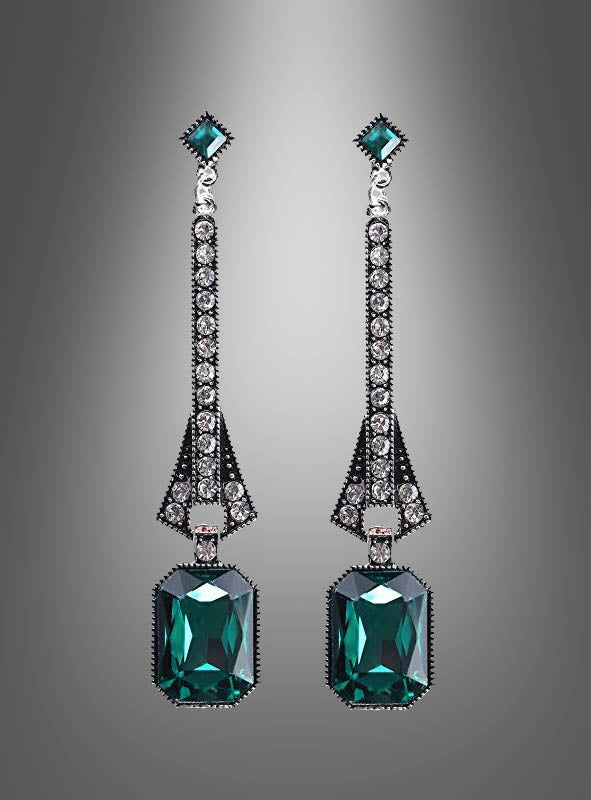 Ein Paar „Elegante Ohrringe für Damen, Silber“ mit langem, silbernem Tropfendesign, verziert mit grünen Edelsteinen und kleinen klaren Steinen, die symmetrisch angeordnet sind, dargestellt vor einem grauen Hintergrund mit Farbverlauf.