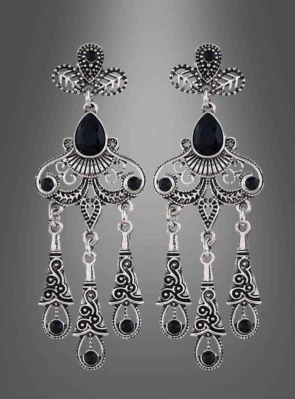 Elegante Ohrringe für Damen aus Silber mit filigranem Design, schwarzen Edelsteinen und drei beweglichen Anhängern pro Ohrstecker, präsentiert vor einem grauen Hintergrund mit Farbverlauf.