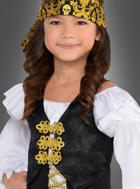 Ein Kind mit einem goldgemusterten Stirnband, einem weißen Rüschenhemd und einer schwarzen Weste mit Goldbesatz steht vor einem grauen Hintergrund – perfekt für das Piratenkostüm für coole Mädchen.
