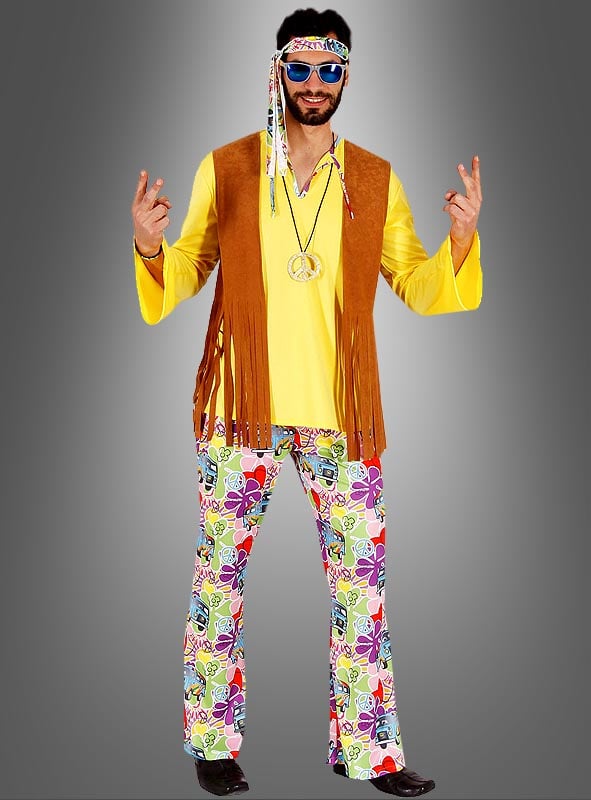 Ein Mann im 70er-Jahre-Hippie-Bernd-Herrenkostüm, bestehend aus einem gelben Hemd, einer braunen Weste mit Fransen, einer bunt gemusterten Hose, einer Sonnenbrille und Peace-Zeichen-Anhängern – er verkörpert den klassischen Flower-Power-Stil voll und ganz, während er mit beiden Händen das Peace-Zeichen macht.