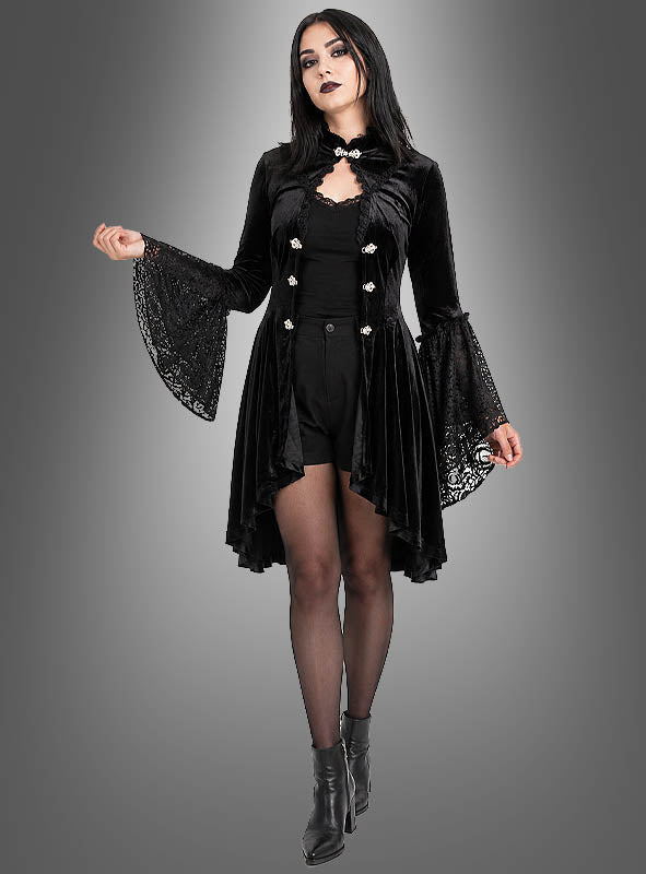 Eine Frau, die das Gothic-Kleid „Lucy mit Spitze“ mit Trompetenärmeln, schwarze Shorts, transparente Strumpfhosen und Stiefeletten trägt und vor einem grauen Hintergrund mit Farbverlauf steht.
