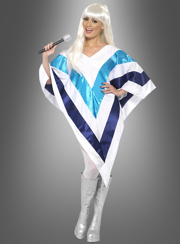 Die Person trägt einen „Poncho im Stil einer Popsängerin der 70er Jahre“ mit weiß-blauem geometrischem Muster, dazu weiße Stiefel und eine lange weiße Perücke; sie hält ein Mikrofon in der Hand und steht im Disco-Look der 70er Jahre vor einem grauen Hintergrund.