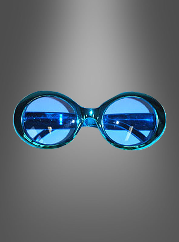 Hippie-Sonnenbrille im Metallic-Look: Blau getönte Sonnenbrille mit runden Gläsern und einem breiten Kunststoffrahmen im Retro-Stil, inspiriert vom Chrom-Look der 70er Jahre, vor einem grauen Farbverlaufshintergrund.