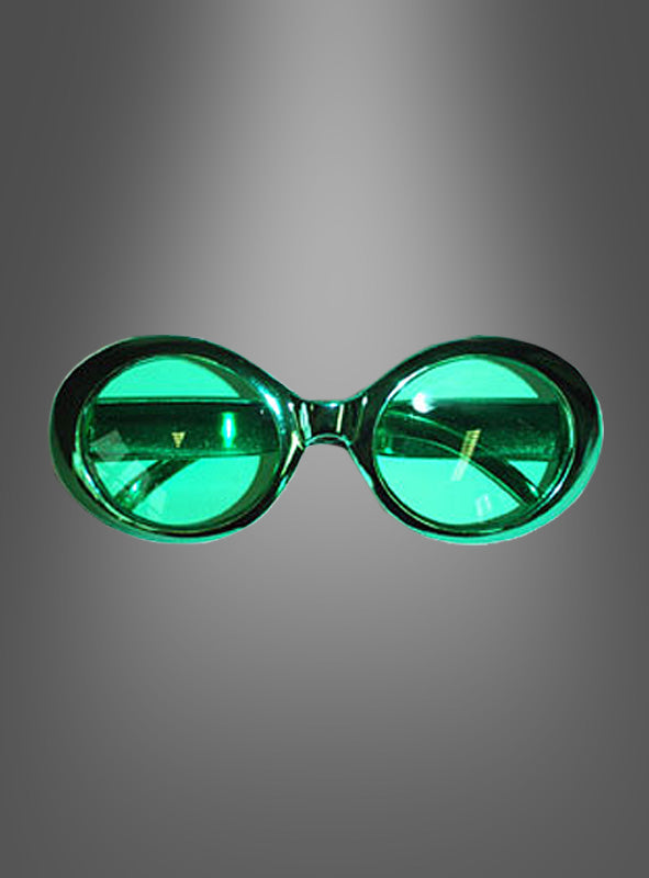 Brille im Hippie-Metallic-Look: Grün getönte, ovale Brille mit dickem Rahmen, von vorne betrachtet und vor einem grau verlaufenden Hintergrund, die ein unverkennbares 70er-Jahre-Flair versprüht und durch eine modische Metallic-Optik hervorgehoben wird.