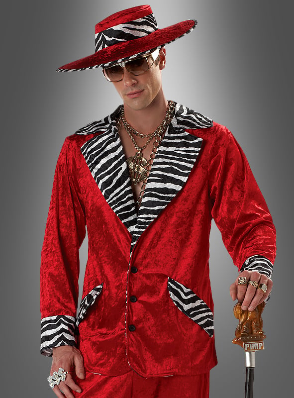 Ein Mann im „Zuhälter-Outfit in Rot mit Zebramuster“: ein leuchtend roter Anzug mit Details im Zebramuster, ein breitkrempiger Hut, überdimensionaler Goldschmuck, eine Sonnenbrille und ein Spazierstock mit der Aufschrift „PIMP“ vor grauem Hintergrund – ein kultiger Retro-Look, perfekt für jede 70er-Jahre-Party oder jede Themenveranstaltung.