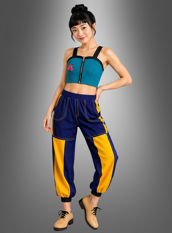 Vor einem grauen Hintergrund mit Farbverlauf steht eine Frau, die das K-Pop-Sängerin-Zomy-Damenkostüm trägt – ein blaugrünes Crop-Top mit Reißverschluss, eine blau-gelb gemusterte Jogginghose und hellbraune Schnürschuhe –, und verkörpert damit die pulsierende Energie eines K-Pop-Idol-Looks, der sich perfekt für Anime-Partys oder Cosplay-Veranstaltungen eignet.