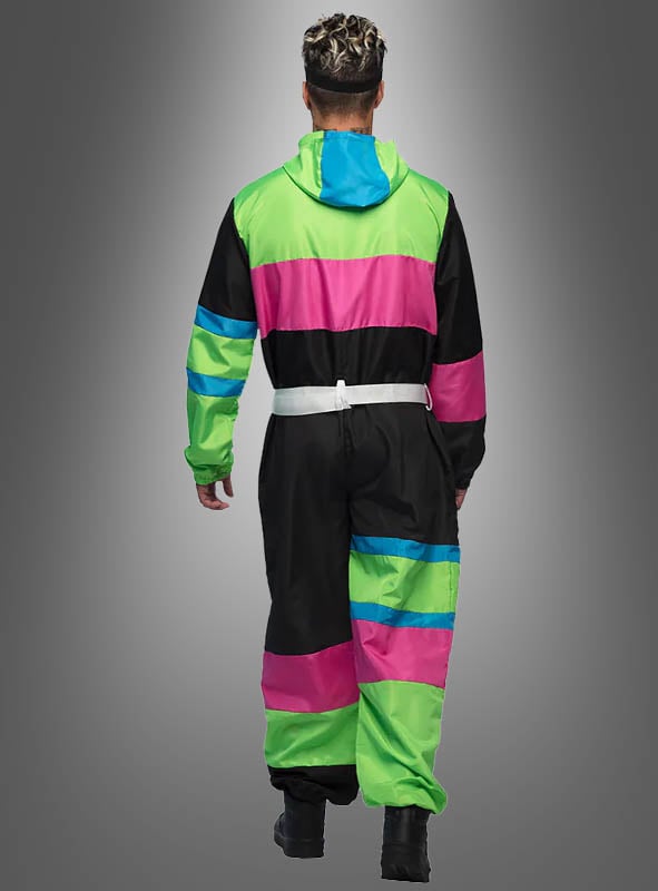 Eine Person, die den „Retro-Skianzug mit Brille“ trägt – einen farbenfrohen Overall mit Kapuze in grünen, rosa, blauen und schwarzen Streifen –, ist von hinten vor einem grauen Hintergrund mit Farbverlauf zu sehen. Damit ist er die perfekte Wahl für Ihre nächste 80er-Jahre-Party.