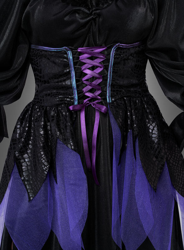Nahaufnahme des „Düstere Gothic Elfe“-Damenkostüms, bestehend aus einem schwarzen Kleid, das mit glänzenden Schuppen verziert ist, einem Korsett mit violetter Schnürung sowie mehrlagigem, blütenblattförmigem Stoff in Violett und Schwarz an der Taille.